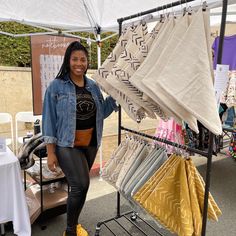 a woman standing next to a display of cloths