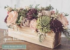 a wooden box filled with flowers on top of a table