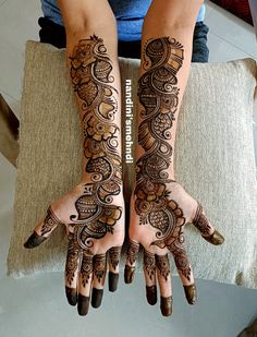 two hands with henna tattoos on them