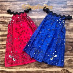 two different colored skirts are sitting on a wooden surface together, one is red and the other is blue