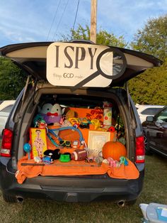 the back end of a car with toys in it and an i spy sign on top