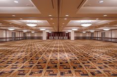 an empty ballroom with carpeted floors and chandeliers