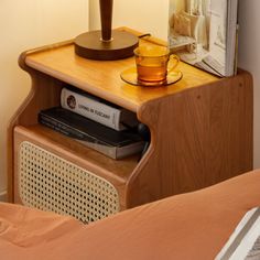 a nightstand with a lamp and books on it