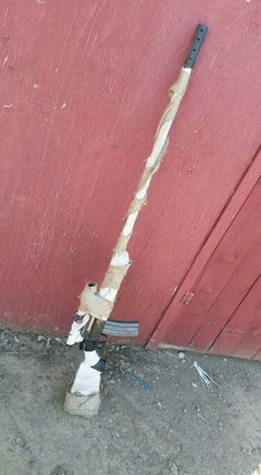 a broken pipe sticking out of the side of a red building next to a door