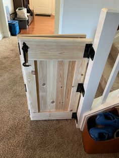 an open wooden door in the middle of a room next to a pair of shoes