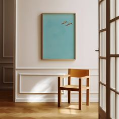 an empty room with a chair and a painting on the wall in front of it