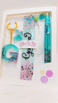 an assortment of items in a box with the word glitter written on one side and two key chains attached to each other