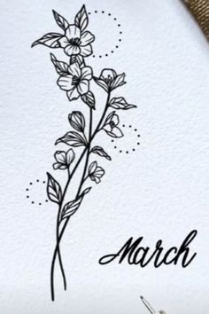 the word march is written in black ink on a white paper with flowers and leaves