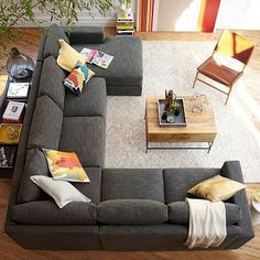 an overhead view of a living room with couches, tables and bookshelves