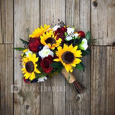 a bridal bouquet with sunflowers and roses on a wooden background for a rustic wedding