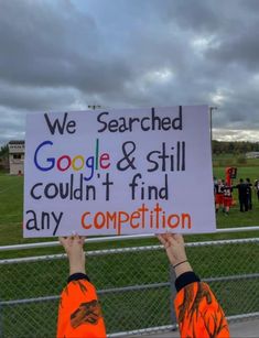 two people holding up a sign that says we search google & still couldn't find any competition