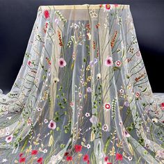 an embroidered sheer fabric with flowers on it