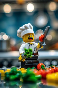 a lego chef is holding a knife and some peppers on the counter next to it