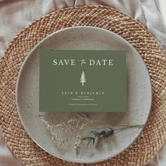 a white plate with a green save the date card on it