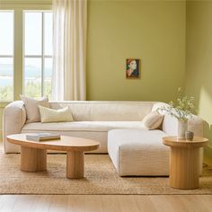 a living room with green walls and white furniture in the corner, along with a large window