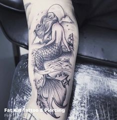 a woman's leg with a mermaid tattoo on it