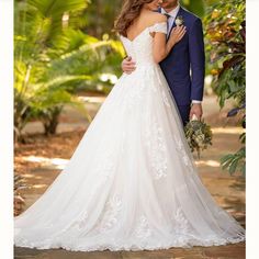 a bride and groom pose for a photo in front of some tropical trees at their wedding