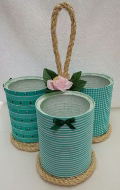 three baskets with flowers are sitting on rope