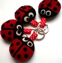 three red and black ladybug keychains with white polka dots on them