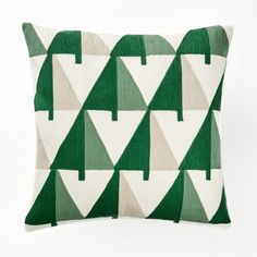 a green and white pillow with trees on it