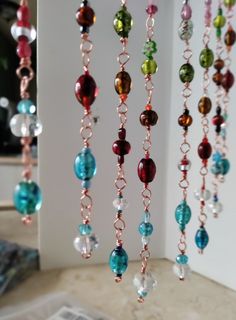 several different colored beads hanging from a chain on a table next to a magazine holder