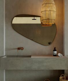 a bathroom with a sink, mirror and basket on the counter top in front of it