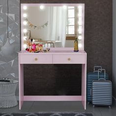 a pink vanity table with a mirror and suitcase