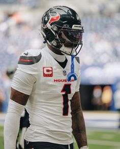 a close up of a football player wearing a uniform and helmet on the sidelines