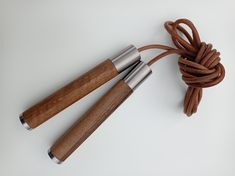 two wooden and metal objects on a white surface, one with a rope attached to it