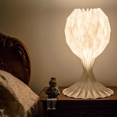 a lamp that is sitting on top of a table next to a teddy bear and bed