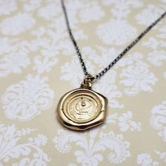 a wax seal necklace on a chain