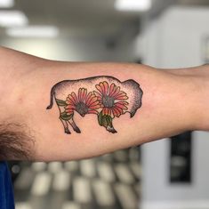 a small pig with flowers on it's arm