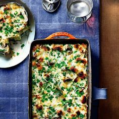 a casserole dish with mushrooms and parsley in it on a blue table cloth