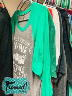 several shirts are hanging on a rack in a clothing store, including one with an rv t - shirt