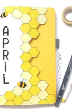 an open notebook with the word april written on it next to a pair of scissors