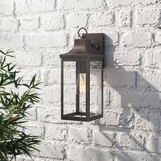 an outdoor light on the side of a white brick wall