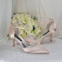 a pair of pink high heeled shoes next to flowers