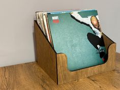 a wooden magazine holder holding magazines on top of a table