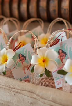 small baskets filled with white and yellow flowers on top of a wooden table next to other items