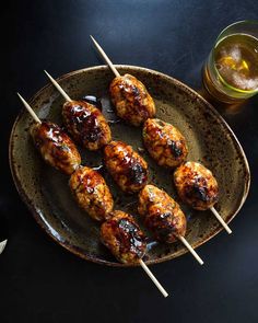 chicken skewers with bbq sauce on a plate next to a drink