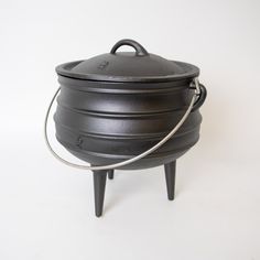 a large black pot sitting on top of a wooden stand