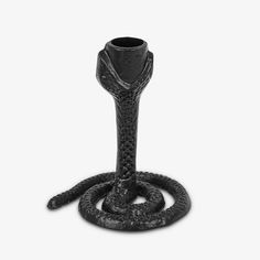 a snake - like object is shown on a white background, it appears to be in the shape of a candle holder