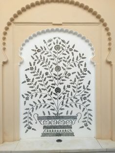 an intricately designed wall in the middle of a building with white and black tiles