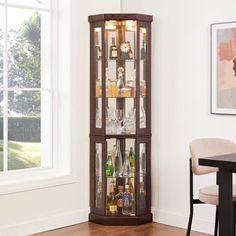 a tall wooden display case with liquor bottles in it's glass doors and shelves