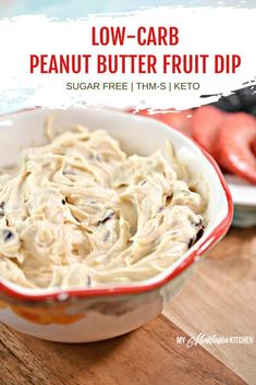 low carb peanut butter fruit dip in a red and white bowl on a wooden table