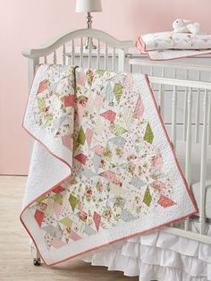 a white crib with a quilt on it