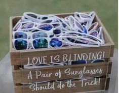 a wooden box filled with sunglasses on top of a table