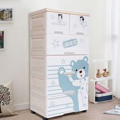 a white and blue toy chest in a child's room with pictures on the wall