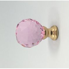 a close up of a pink door knob on a white wall