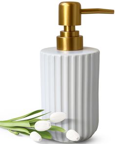 a white ceramic soap dispenser with tulips